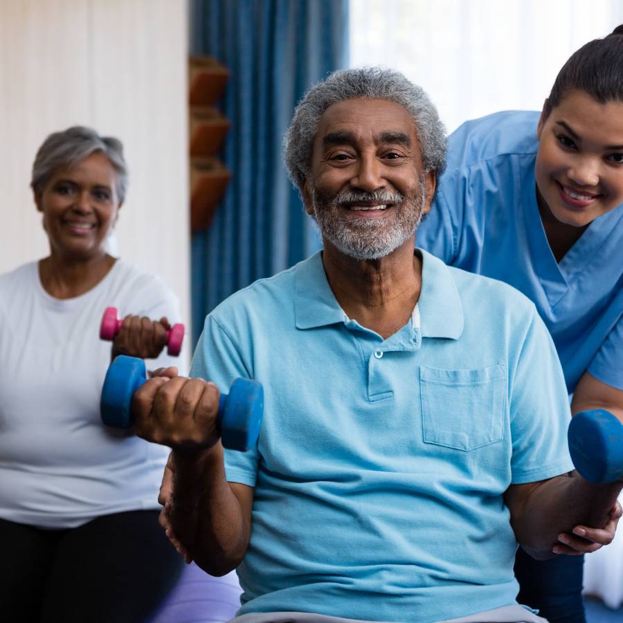 Elderly man and woman exercising with nurse